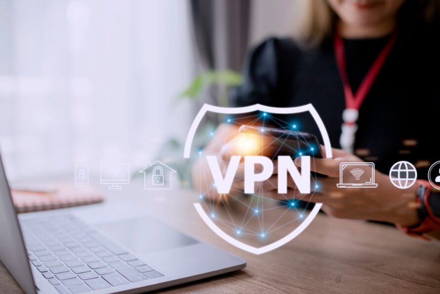 Shield-shaped logo labeled "VPN" overlaid on background of person sitting in front of laptop computer