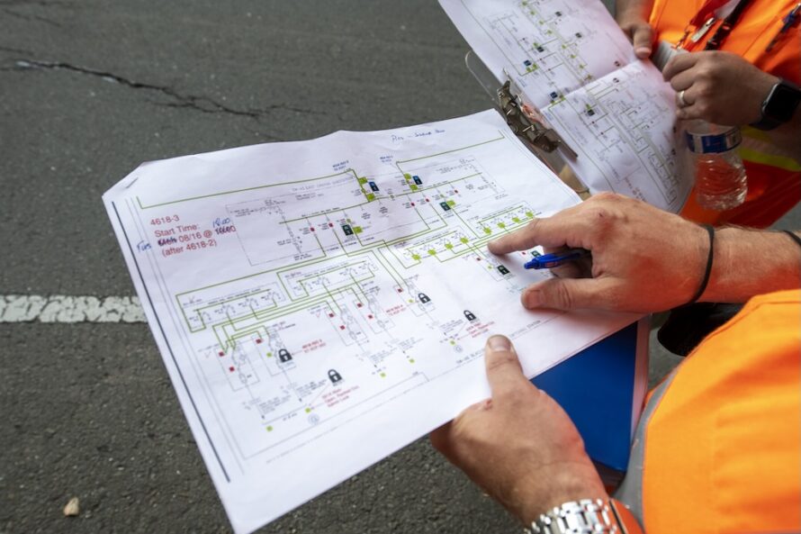 Closeup of person's hands holding a field plan and pointing to a specific area of the plan.