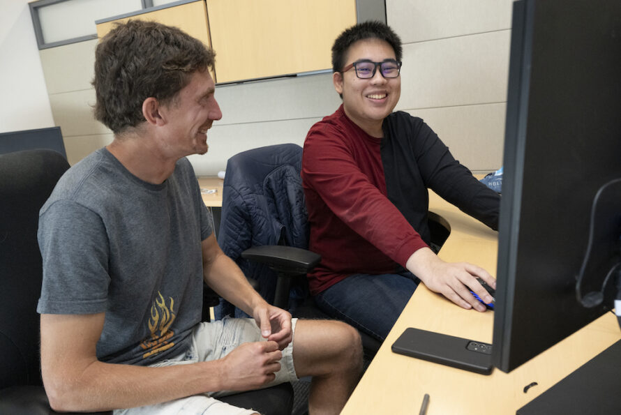 Berkeley Lab chemistry intern sitting with mentor at a computer discussing a research project.