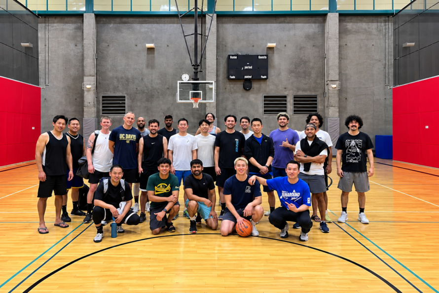 Berkeley Lab basketball team members posing for photo on basketball court with first row of five persons sitting and second row of 13 persons standing.