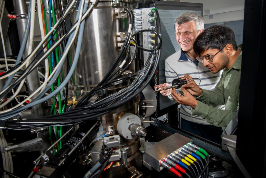 two people examining scientific instrument