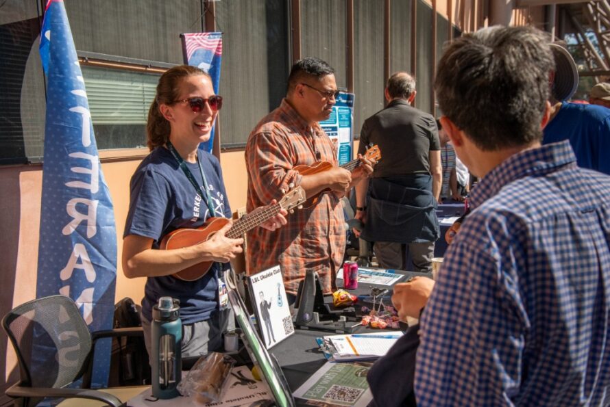 Action shot of several people interacting at a booth at the Finish Line Festival