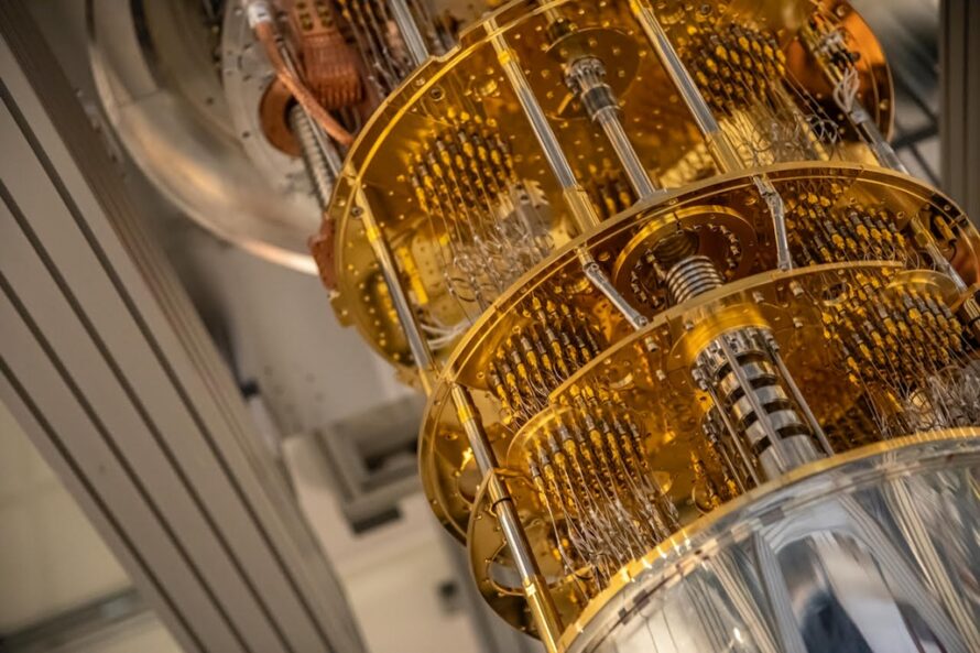 A multi-tiered silver and gold cylindrical metal device AQT Fridge installation at Berkeley Lab.