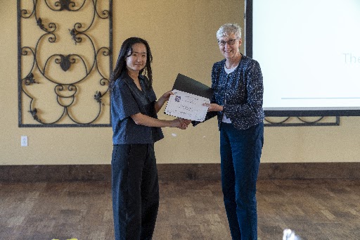One person accepting award certificate from another person.