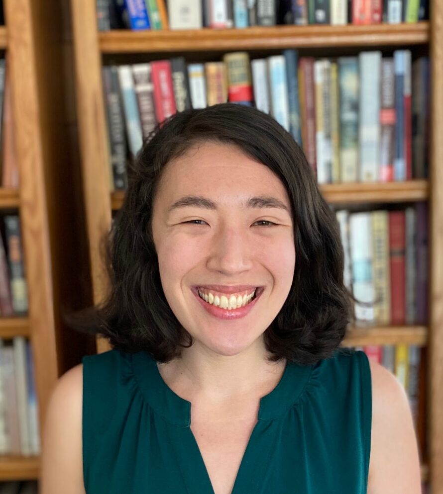 Closeup of Kyana Van Houten, a person with should-length black hair wearing a black top and smiling.